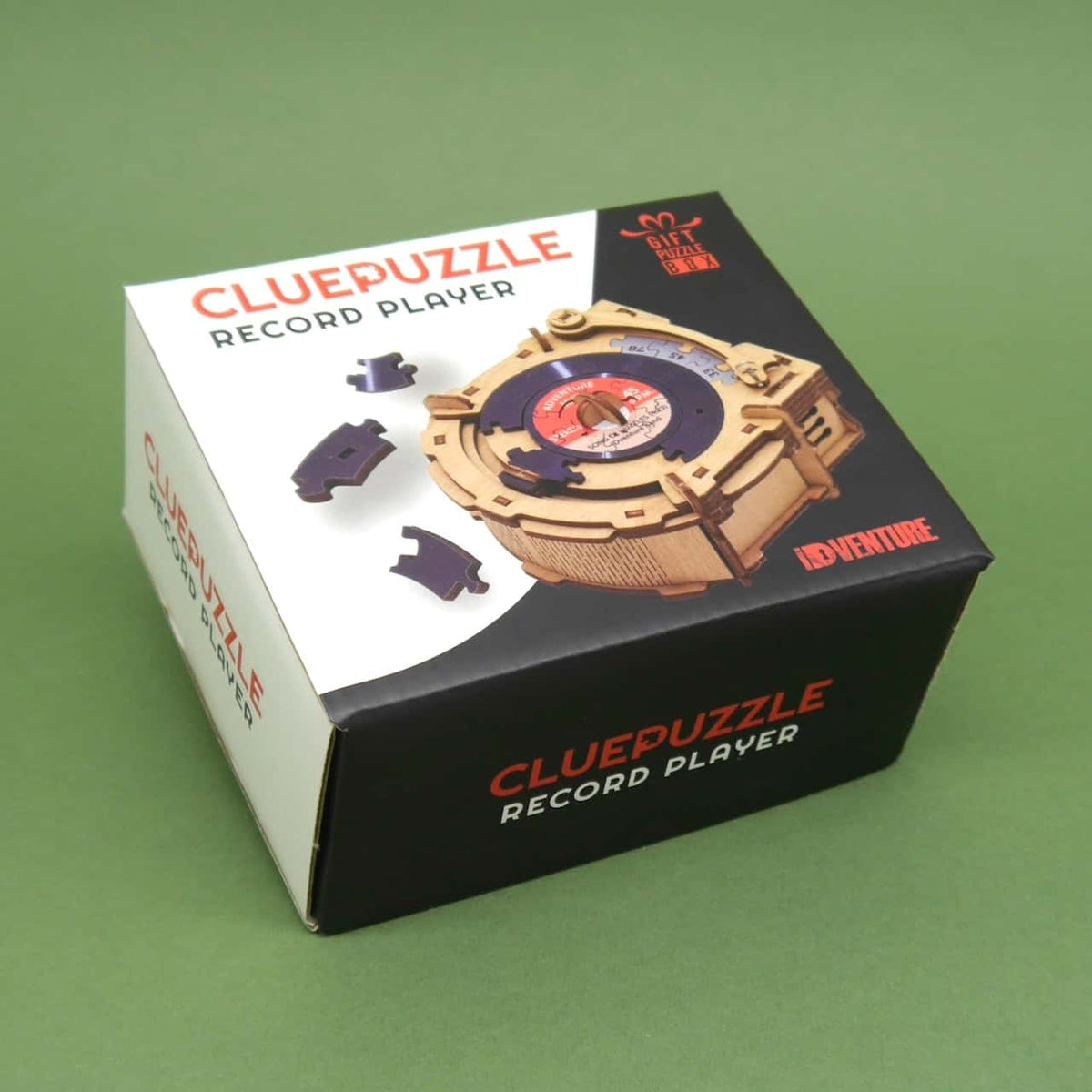 Fertiges Holzpuzzle eines Mini-Plattenspielers als Knobelspiel; die runde Vinyl-Puzzleplatte ist hochgeklappt und zeigt das Etikett „Adventure Music“.