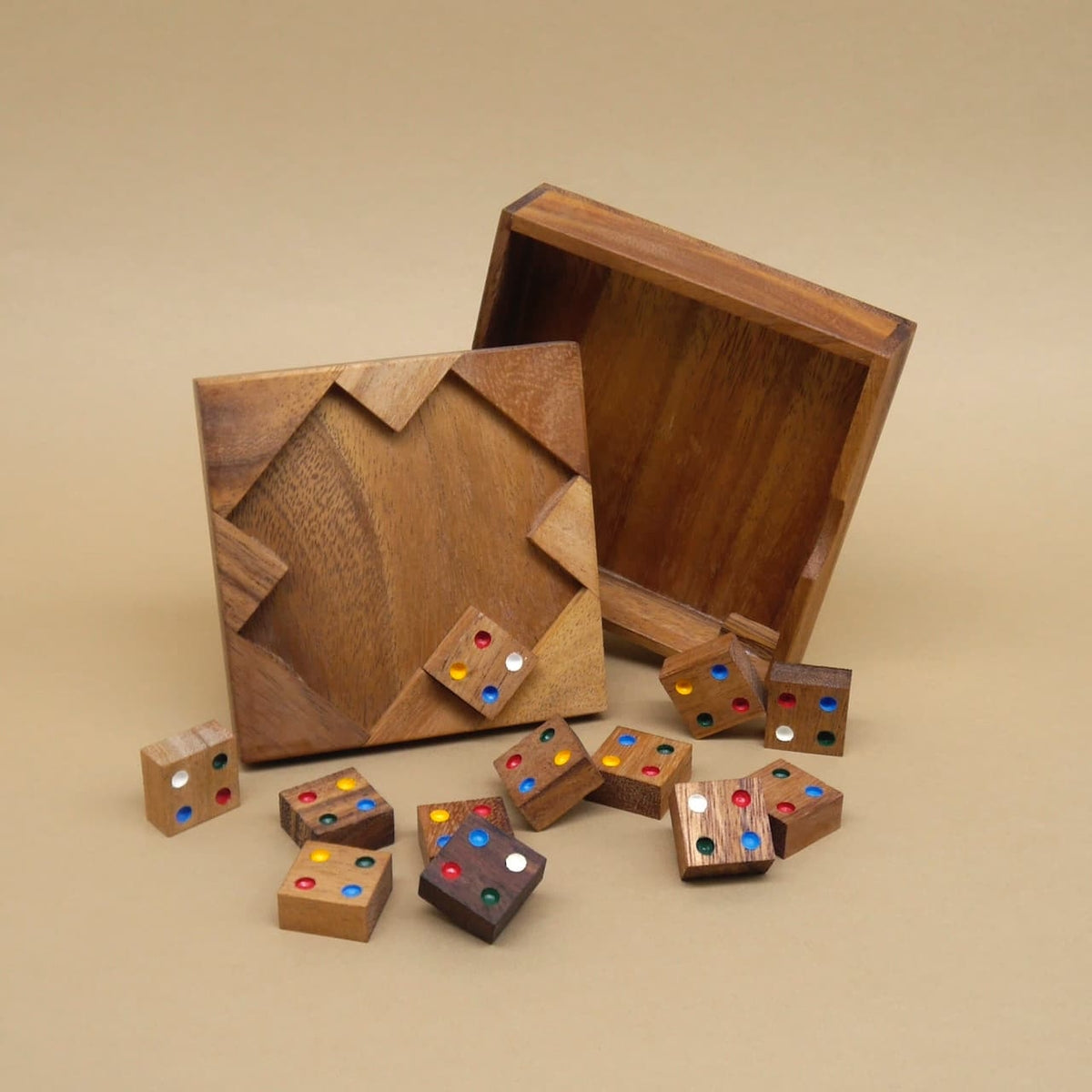 Offene Holzschachtel mit verstreuten Holzsteinen, die ein bunt gepunktetes Geduldsspiel bilden.