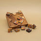 Teilweise gelöstes Logikpuzzle; farbig markierte Holzsteine liegen in und um eine geöffnete Holzbox