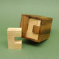 Offene Knobelbox aus Holz; das entnommene C-Element steht davor – ein minimalistischer Brainteaser.