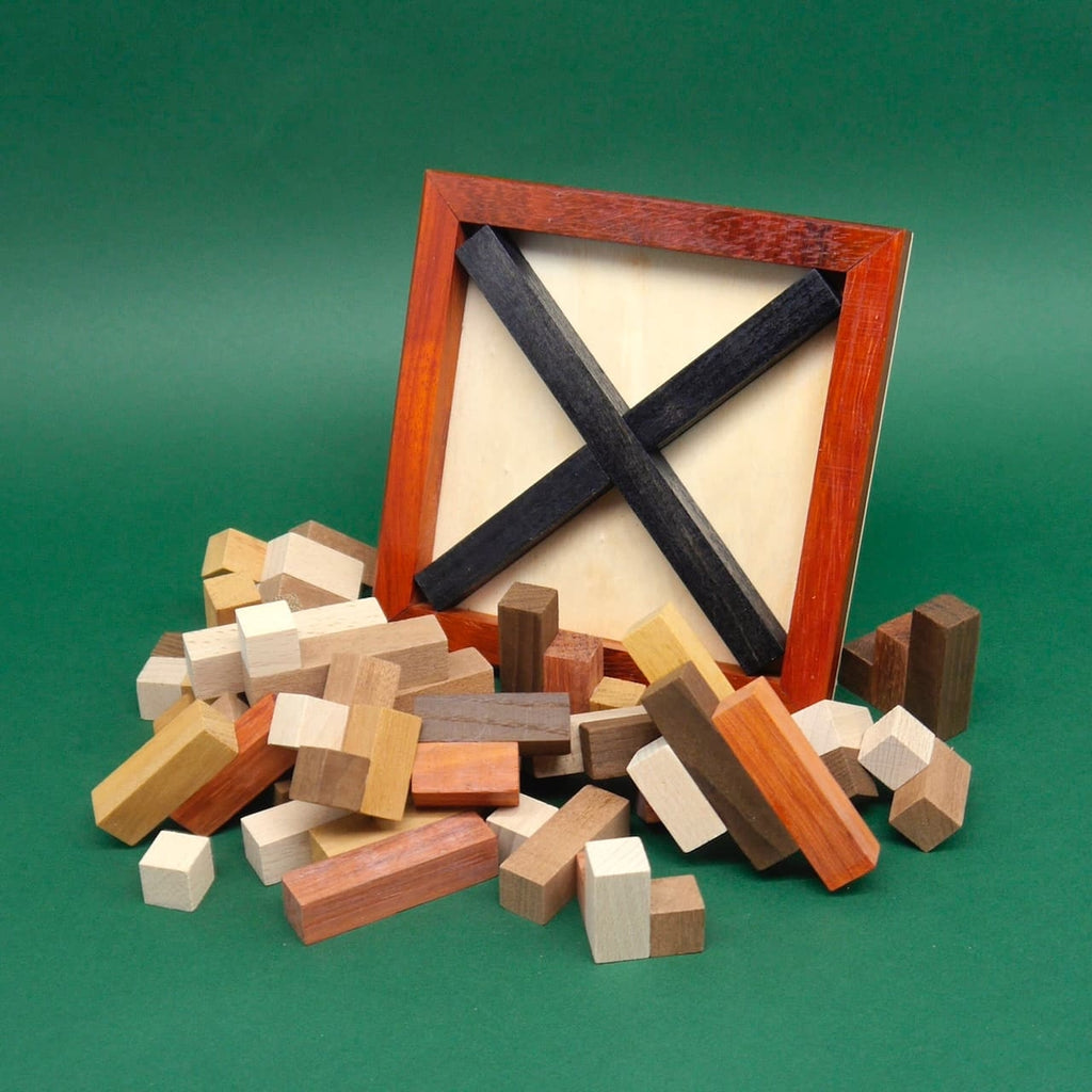 Vollständig zerlegtes Knobelspiel mit vielen unterschiedlich geformten Holzwürfeln, die um den leeren Rahmen herumliegen.