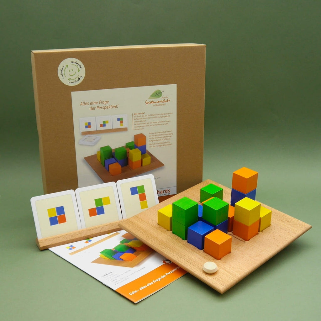 CUBE Gesellschaftsspiel aus Holz: Spielbrett mit bunten Würfeln, Aufgabenkarten und Verpackung.
