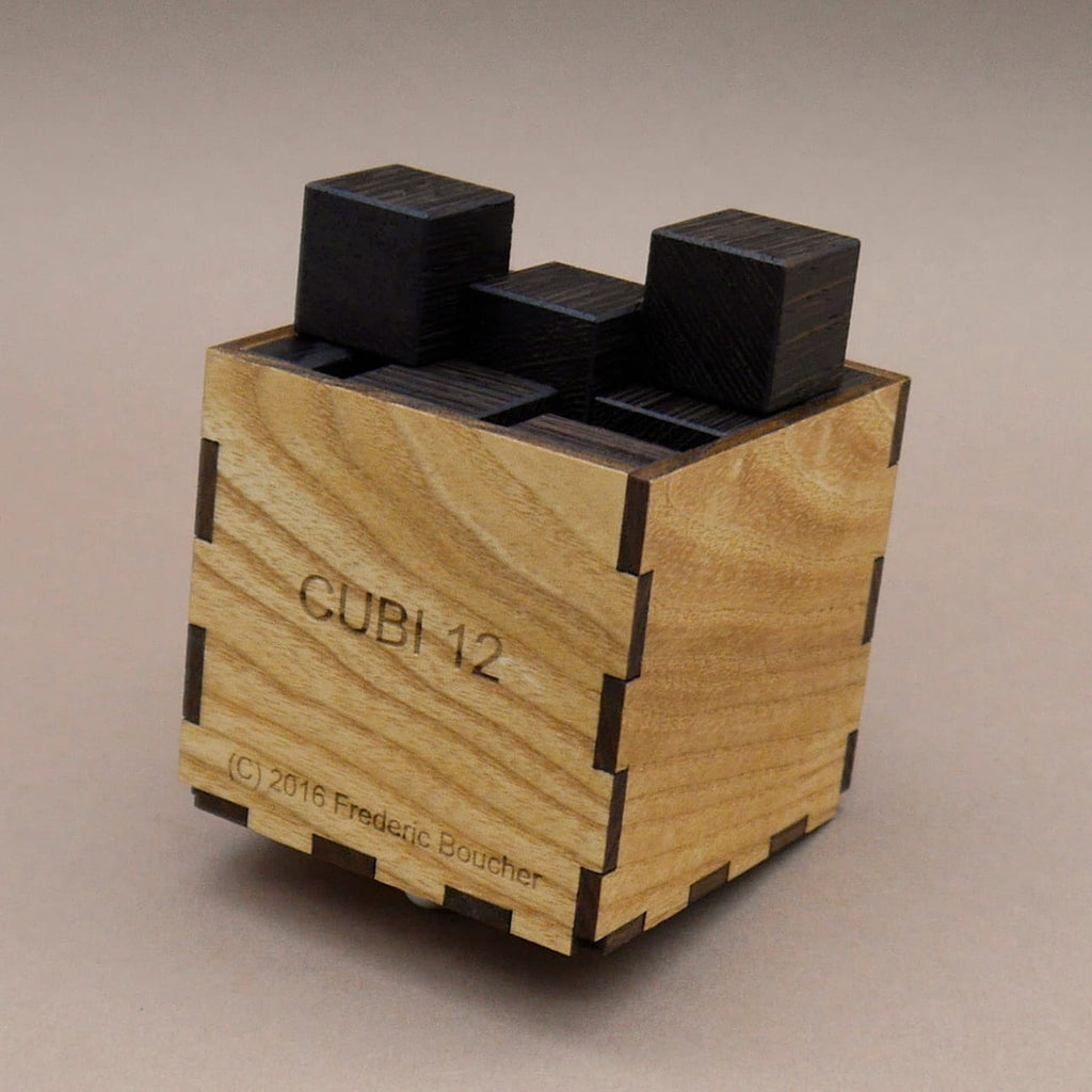 Knobelspiel aus Holz: Würfel sind in einer Box angeordnet, einige ragen oben heraus und zeigen die Lösung.