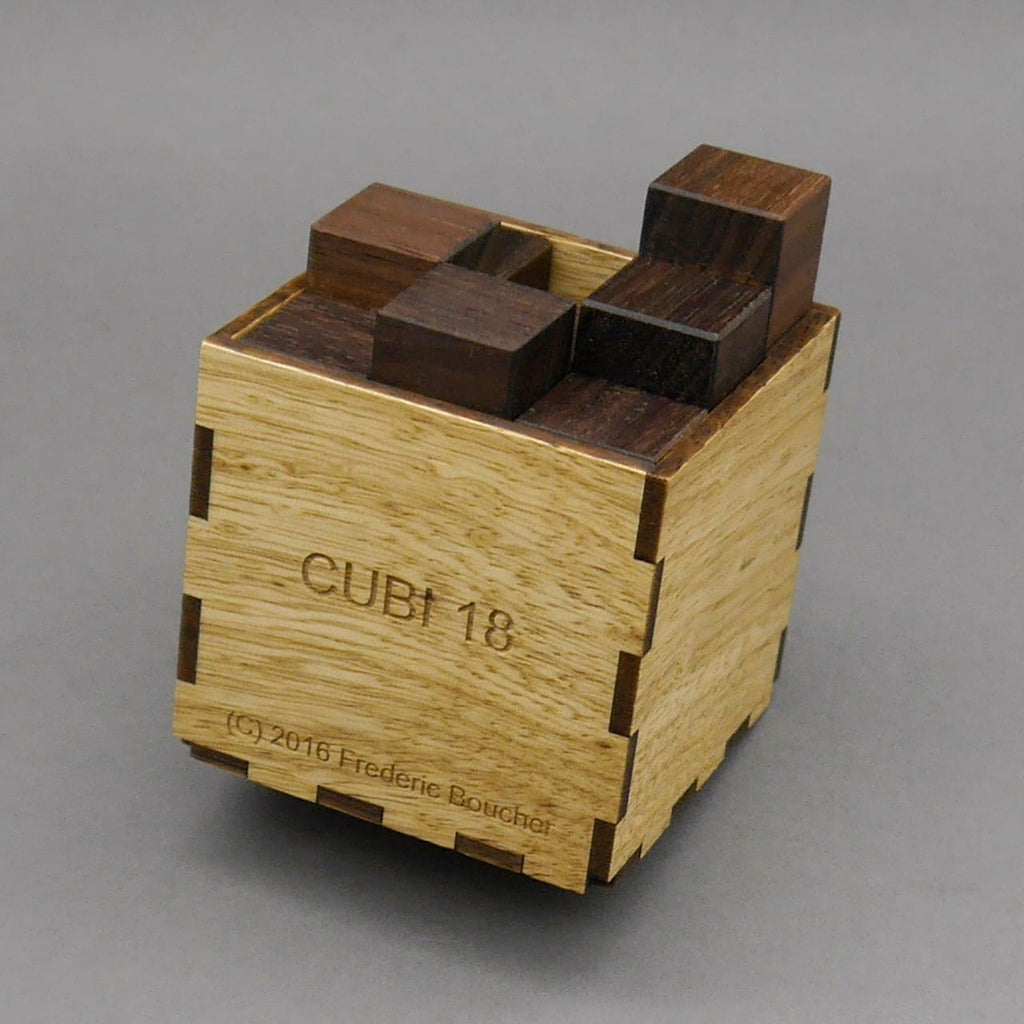 Knobelspiel aus Holz mit Würfelbox: Zusammengesetzte Elemente bilden eine kompakte Form, während die Box das Puzzle elegant umrahmt.