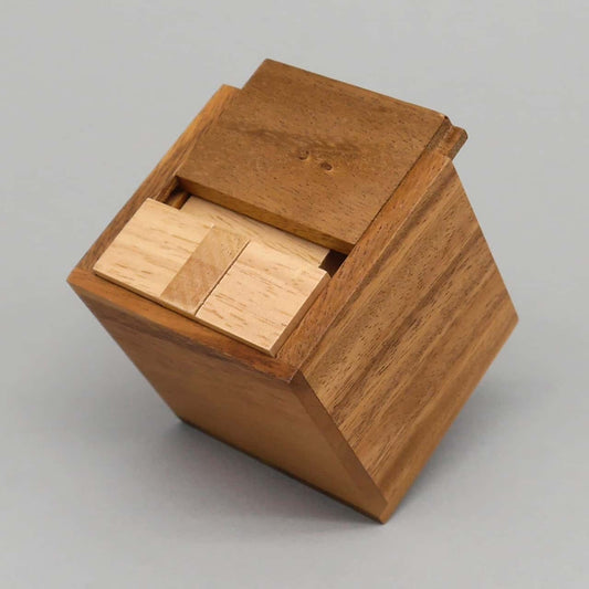 Teilgeöffnete Holzbox mit exakt verstauten Steinen eines anspruchsvollen Packing-Puzzle.