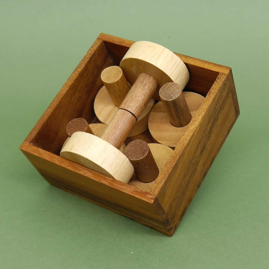 Quadratische Holzschachtel zeigt ein vollständig eingerahmtes Holzpuzzle aus runden Scheiben und Stiften.