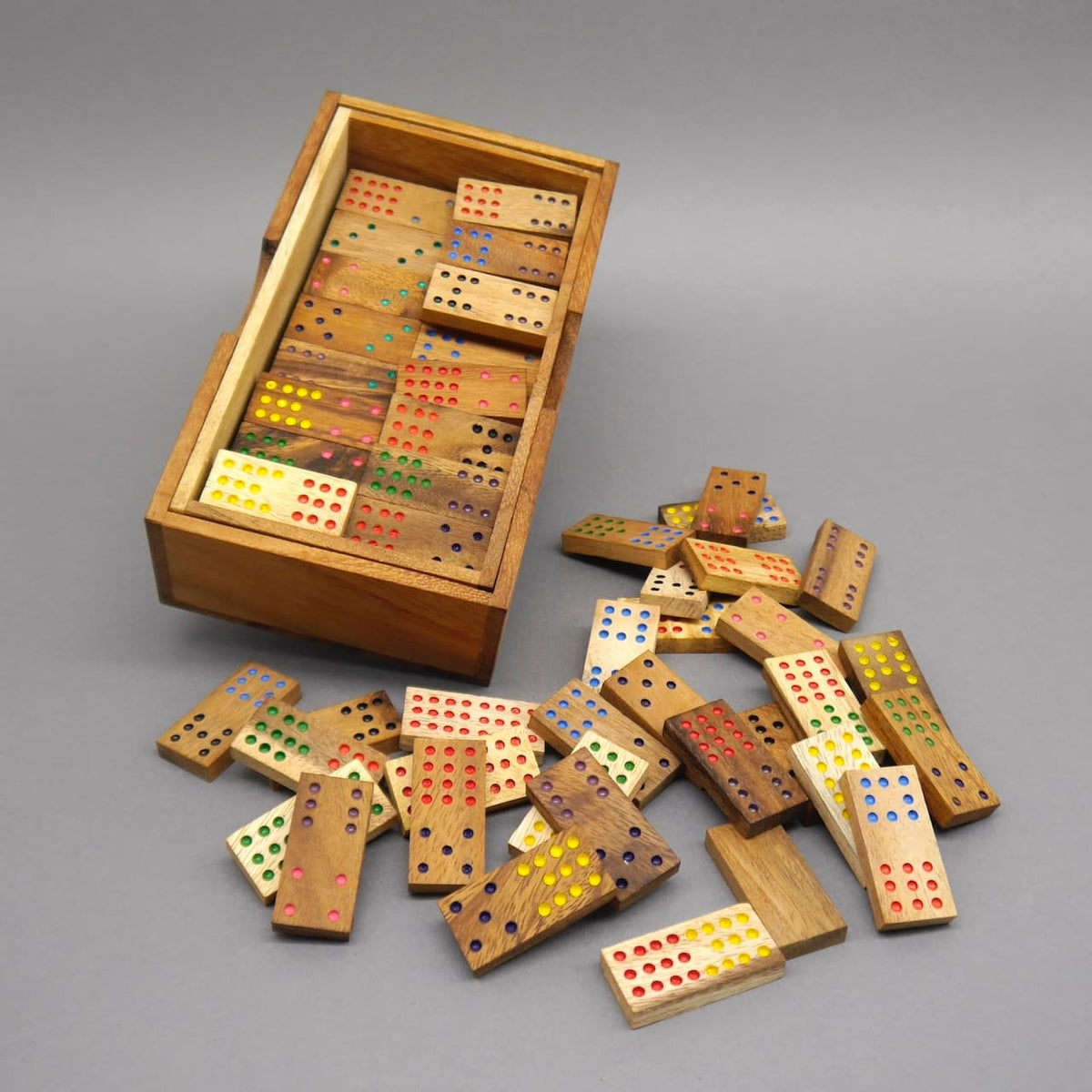 Teilweise geöffnete Holzbox mit farbigen Dominosteinen, ein klassisches Gesellschaftsspiel aus Holz.