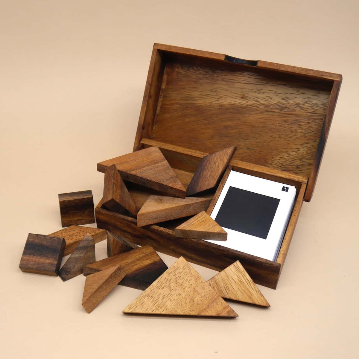 Geöffnete Holzbox mit Tangram-Teilen und Spielkarten – ein kreatives Knobelspiel für zwei Personen.