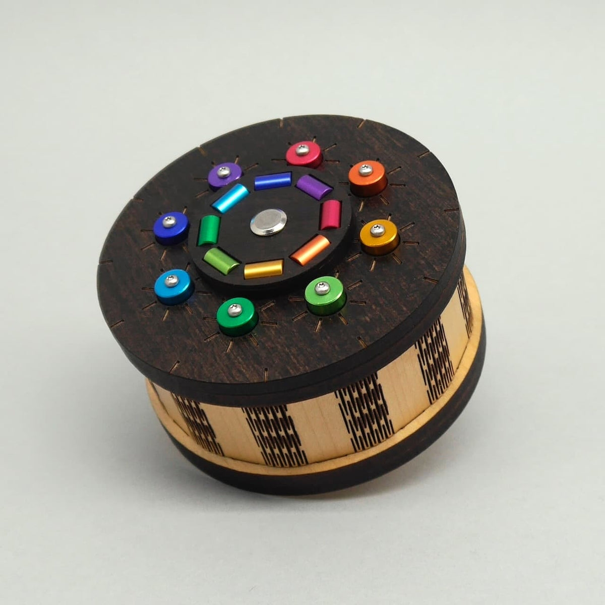 Detailaufnahme einer geschlossenen Holz-Puzzlebox mit bunten Drehknöpfen – ideal als Knobelspiel oder Mystery-Geschenkbox.