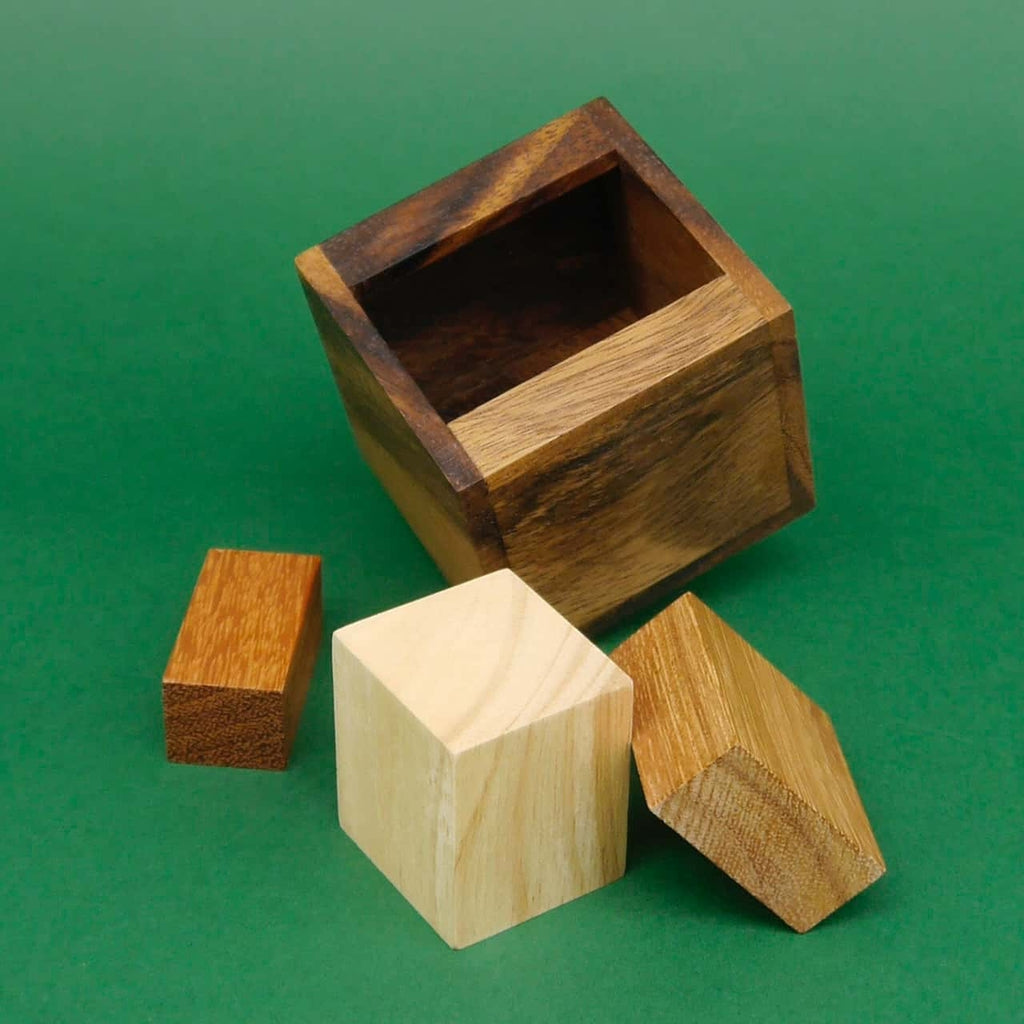 Offenes Holz-Knobelspiel: Drei Puzzleteile liegen bereit, um wieder in den Würfel eingesetzt zu werden.
