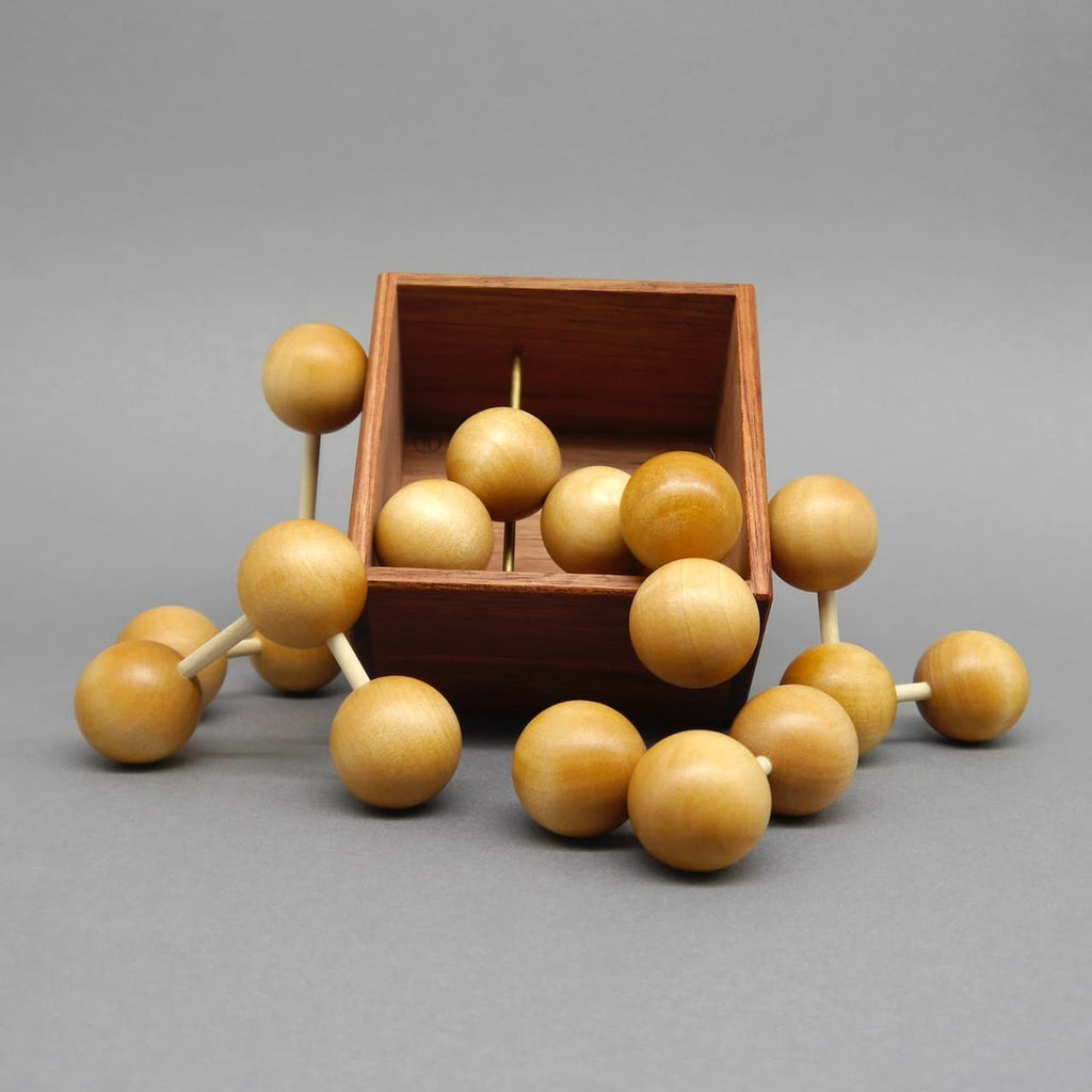 Ein hölzernes Geduldsspiel mit mehreren unterschiedlich geformten Holzteilen, die in eine Holzbox gepuzzelt werden können.