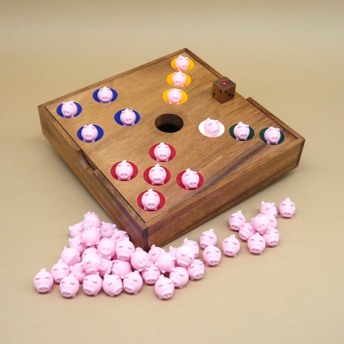 Detailaufnahme vom Ferkelrennen auf dem Spielbrett mit bunten Spielfeldern, Würfel und vielen rosa Schweinchen.