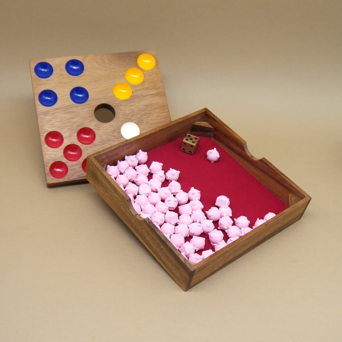 Offenes Gesellschaftsspiel aus Holz mit Spielfiguren in Schweinform und rotem Innenfach zur Aufbewahrung.