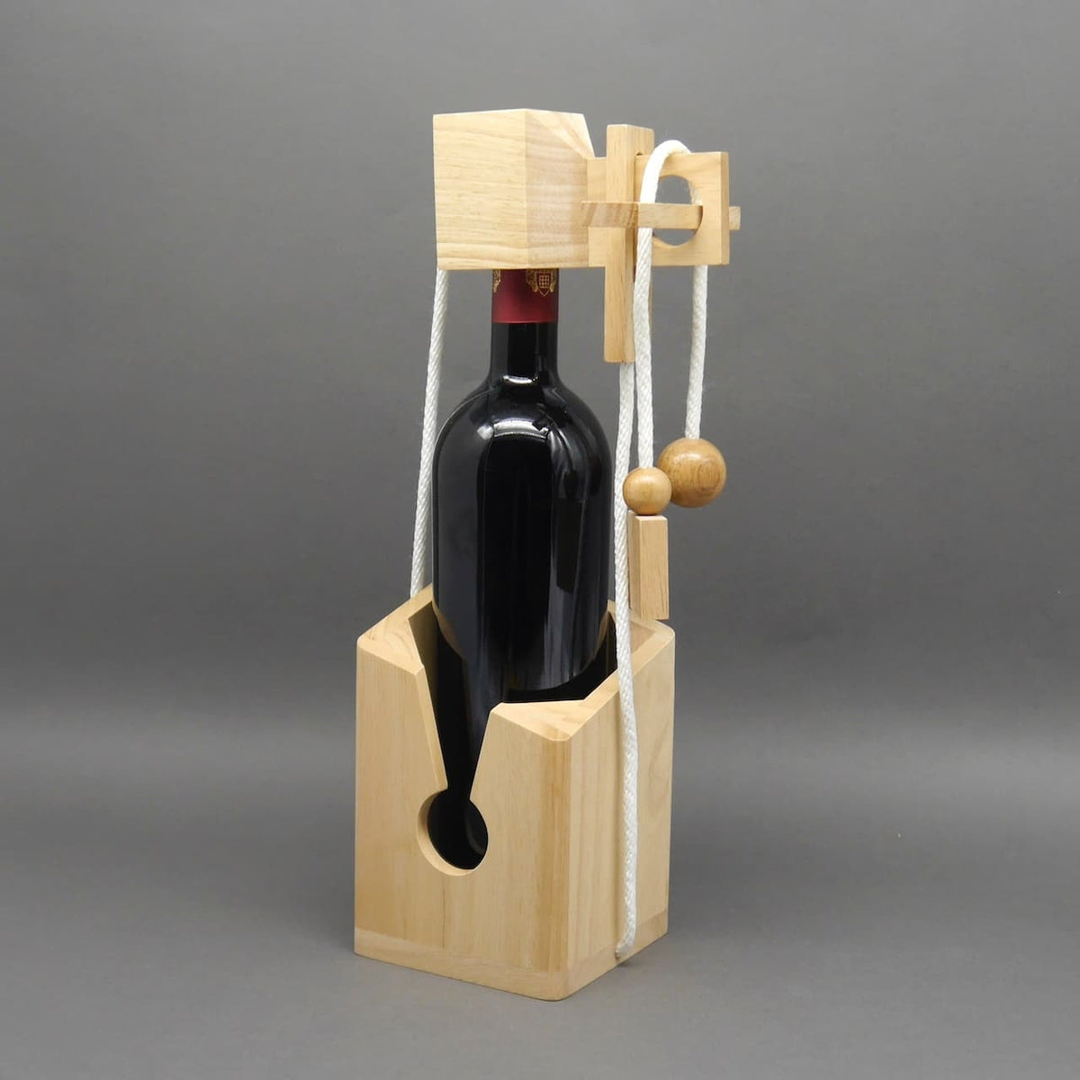 Flaschentresor aus Holz mit Seil- und Kugelmechanik hält eine Rotweinflasche sicher im Halter.