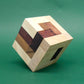 Vollständig zusammengesetztes Würfelpuzzle aus edlen Holzstreifen balanciert auf einer Ecke – spannendes Denkspiel.