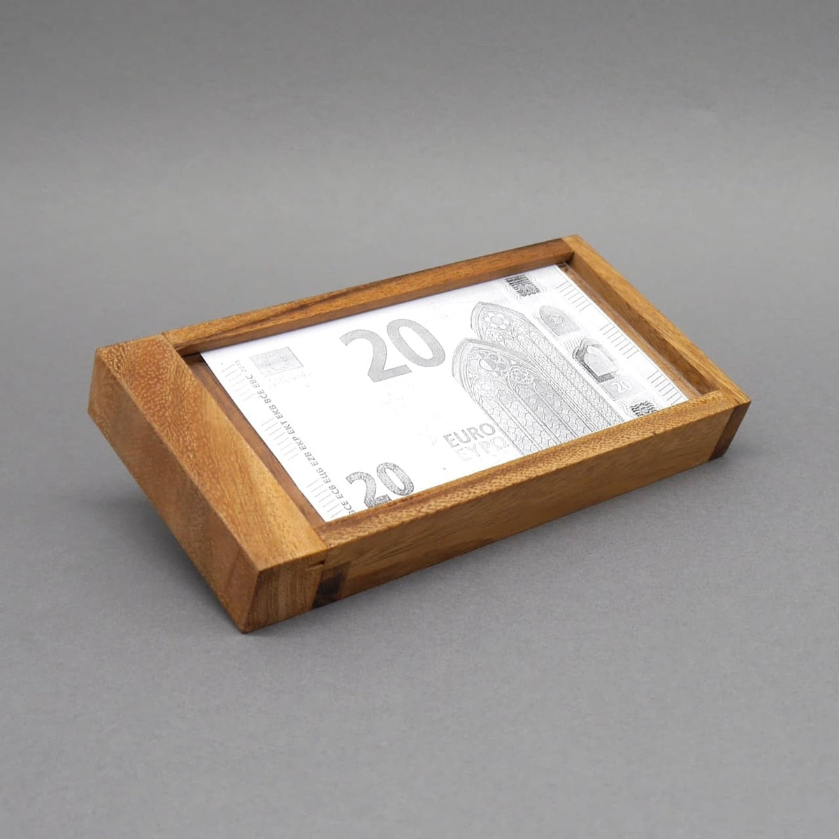 Flachliegende Geldgeschenkbox aus Holz mit eingelegtem 20-Euro-Schein als Knobelspiel zum Verschenken.