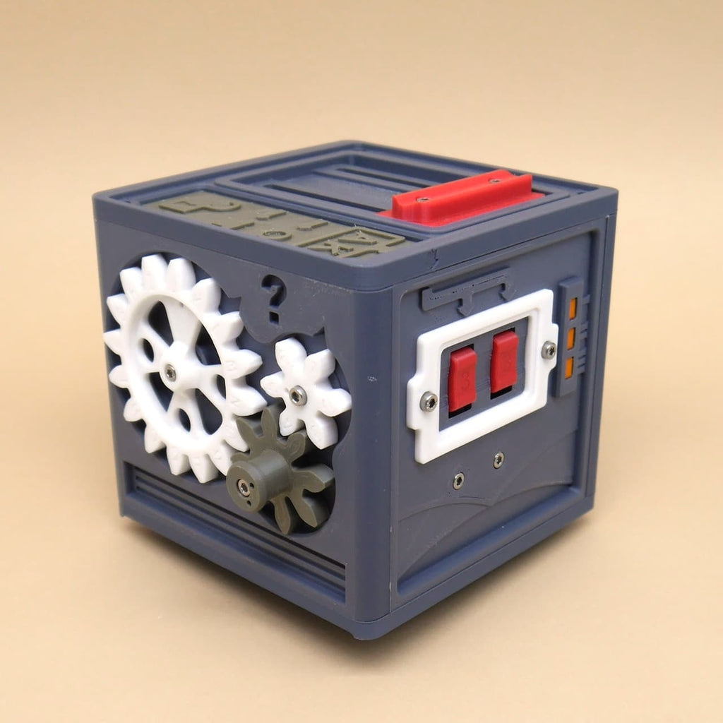 Detaillierte Aufnahme eines würfelförmigen 3D-Puzzles mit Zahnrädern und roten Schaltern an der Seite. Das Rätselspiel wirkt mechanisch und interaktiv.