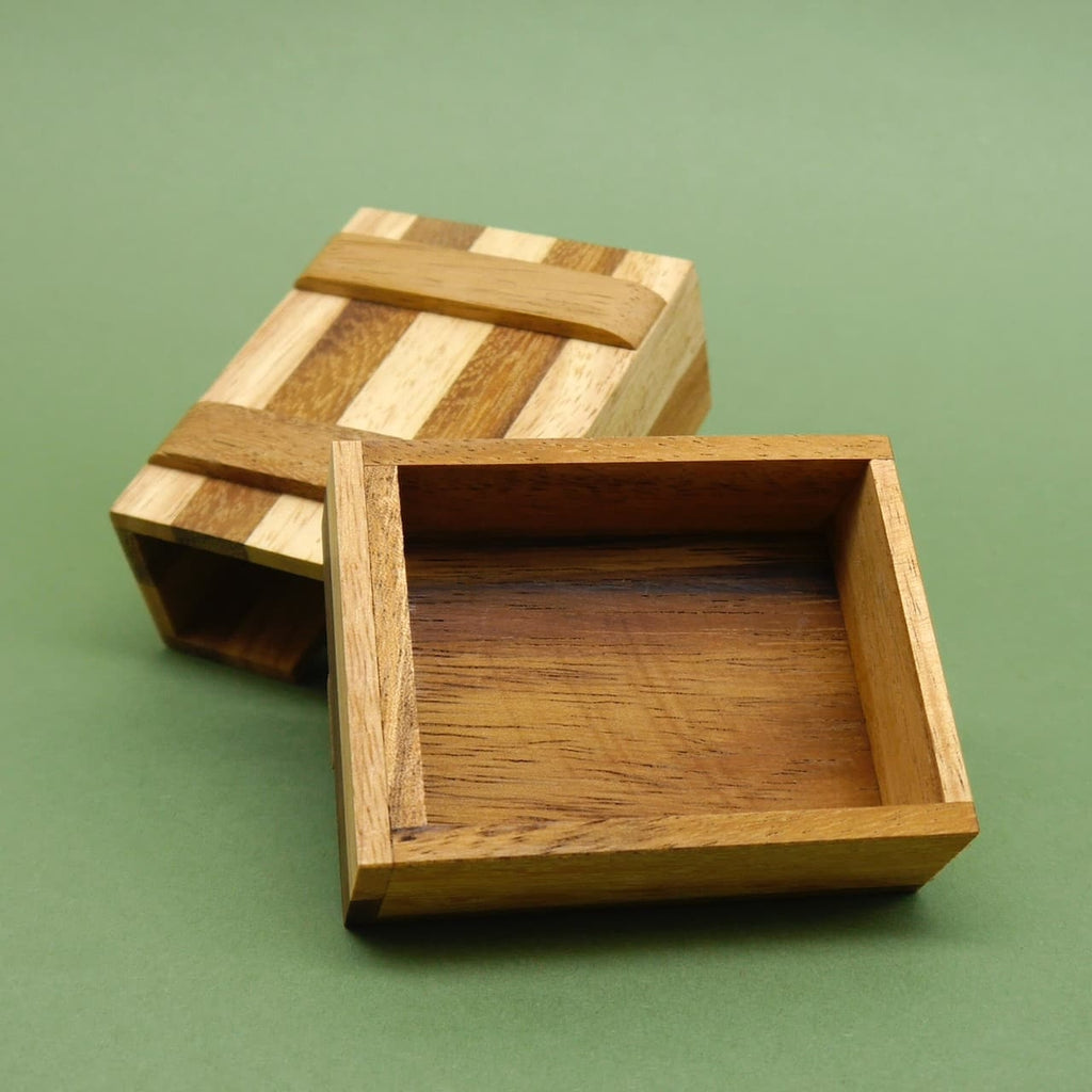 Geöffnete Gutscheinbox aus hell‑dunkel gemasertem Holz; Deckel zurückgeschoben, Innenraum klar erkennbar.