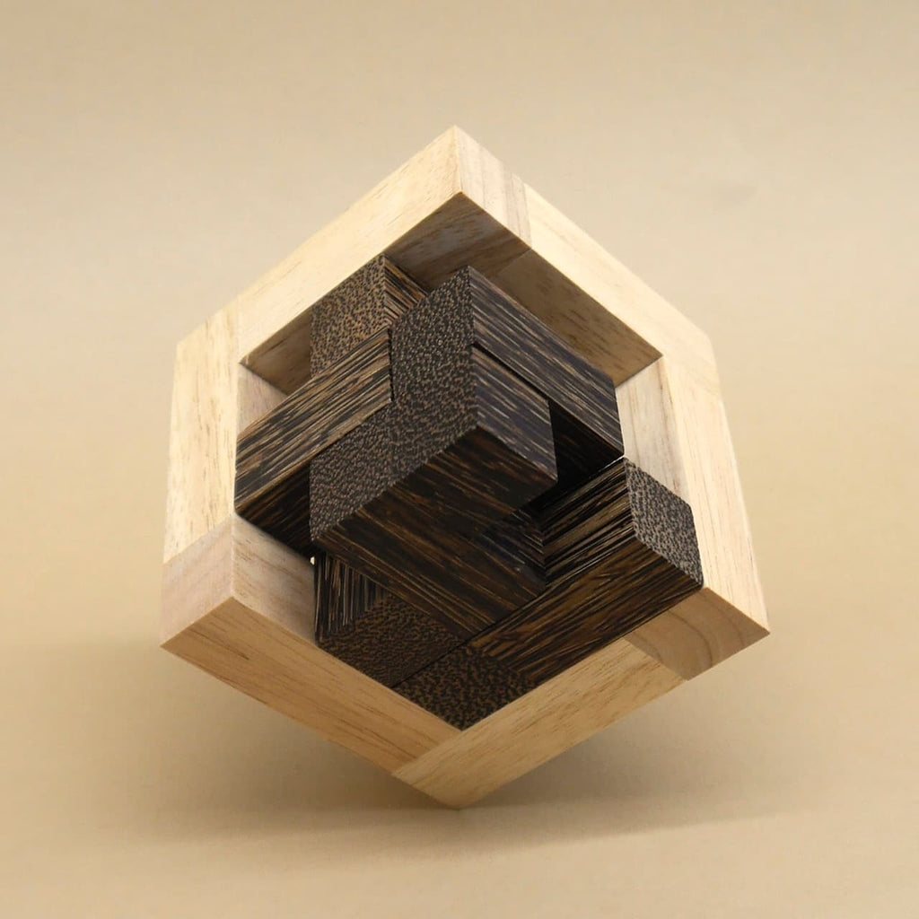 Zu einem Holzwürfel ineinander verschachtelte, helle und dunkle Holzstäbe bilden ein dreidimensionales Geduldspiel.