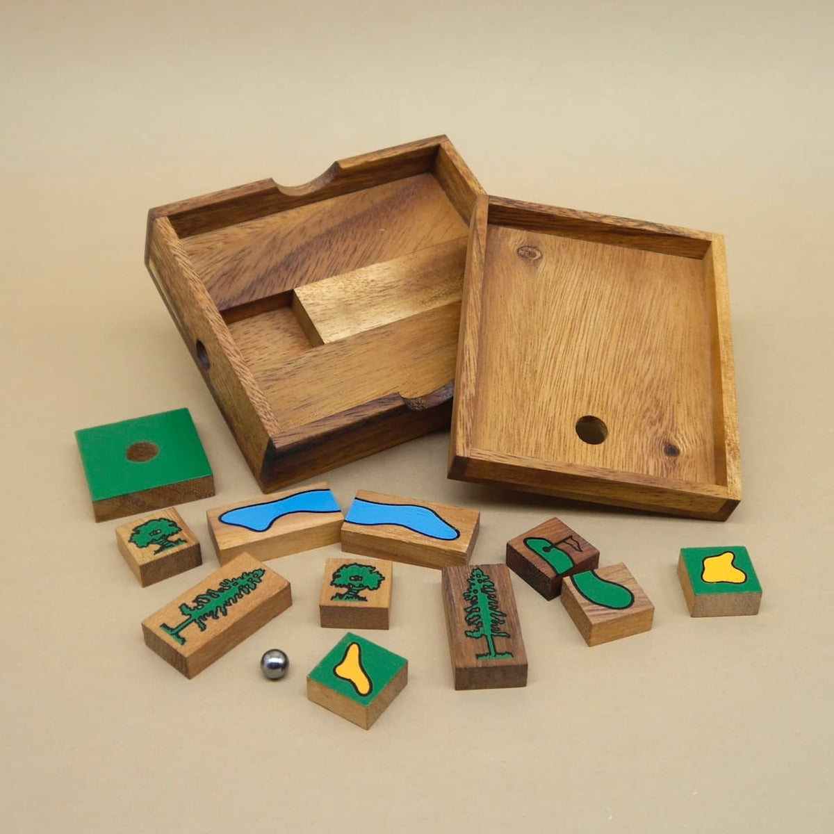 Holz‑Geduldspiel mit geöffnetem Kasten, bunten Golf‑Puzzleteilen und kleiner Metallkugel.