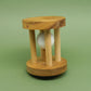 Aufrecht stehendes Knobelspiel aus Holz mit drei Stäben; ein Golfball ist zwischen ihnen eingeschlossen.