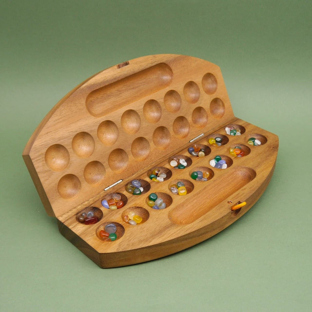 Bohnenspiel aus Holz, aufgeklapptes halbrundes Brett mit Mulden und bunten Steinen