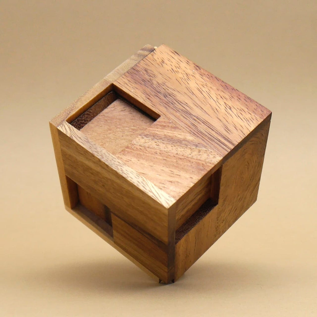 Vollständig zusammengesetztes Packpuzzle „Hexahedroom“ als sauber gefügter Holzwürfel mit eingelassenen Segmenten vor neutralem Hintergrund.