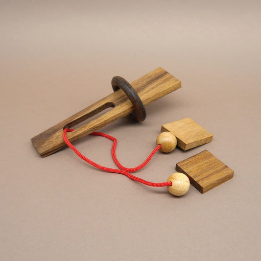 Anspruchsvolles Holzpuzzle mit Schnur, Kugeln und Holzring – ein Denkspiel für Knobelfreunde.
