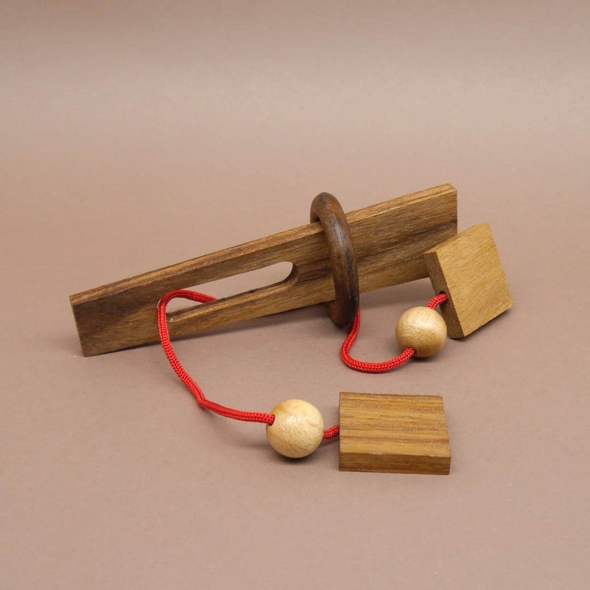 Klassisches Seilrätsel aus Holz mit Ring und Kugeln – ideal für Knobelspaß und geistige Herausforderung.