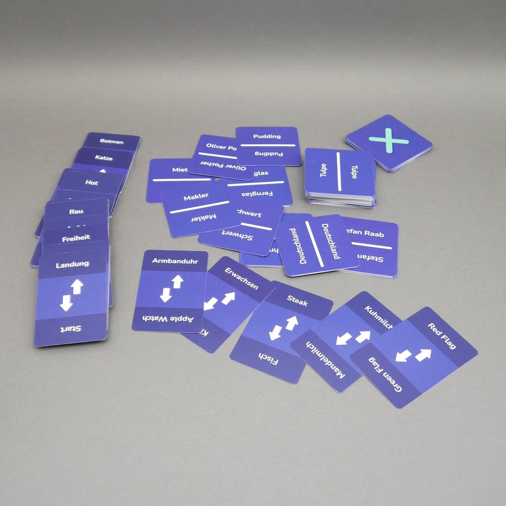 Ausgebreitete blaue „Hot or Cold“-Karten auf dem Tisch; Wörter und Pfeile sichtbar, mehrere Stapel daneben.