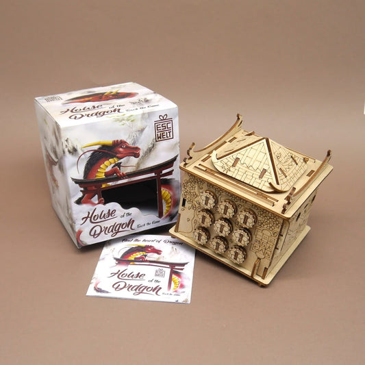 Holzpuzzle ‘House of the Dragon’ neben Verpackung und Anleitung – detailreiche Box im Pagodenstil.