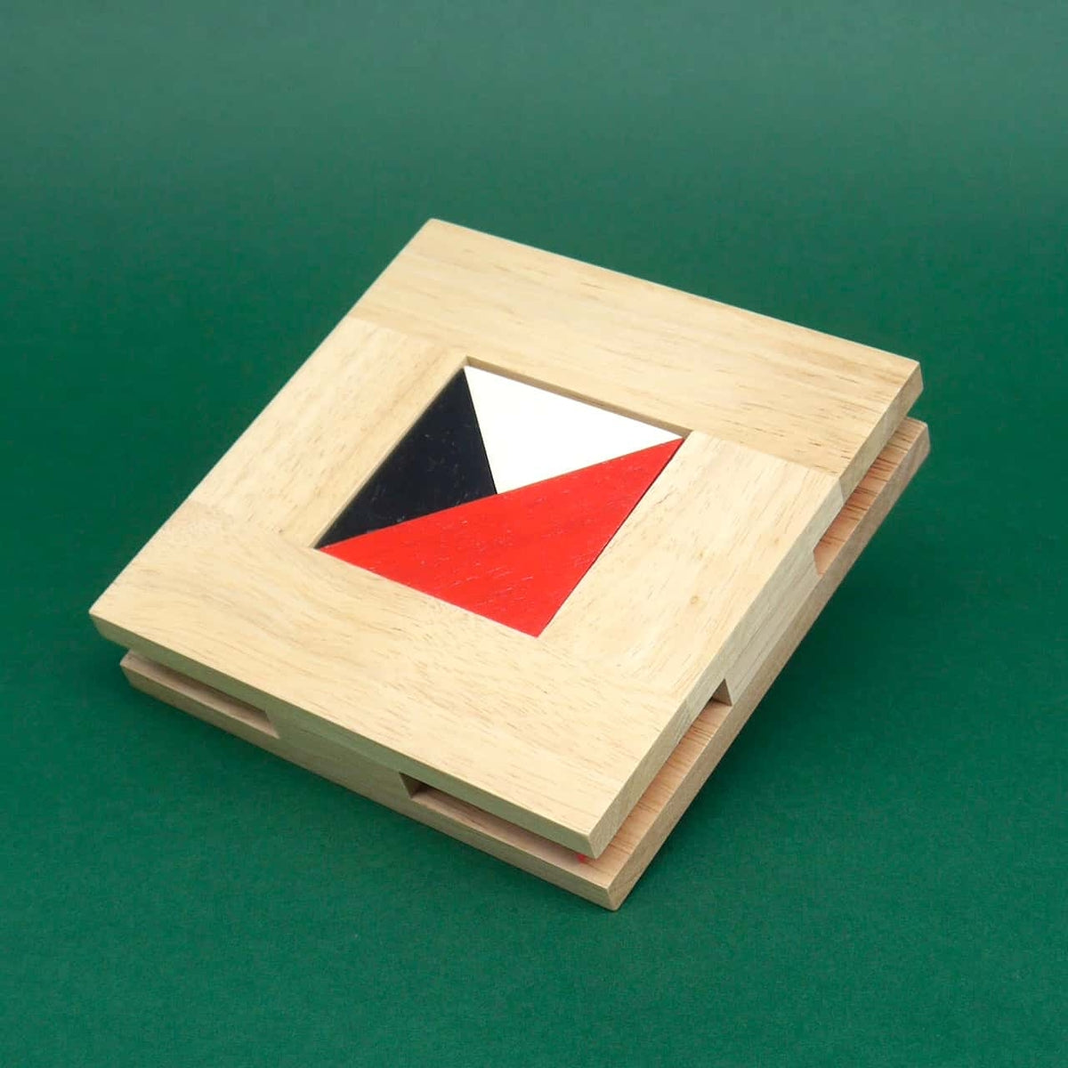 Flach liegendes Holz-Schiebepuzzle, in dessen Mitte rote, weiße und schwarze Dreiecke exakt zusammengeschoben sind.