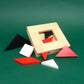 Holzrahmen mit halb eingesetzten roten, schwarzen und weißen Dreiecken – herausforderndes Tangram zum Selbst-Zusammenlegen.