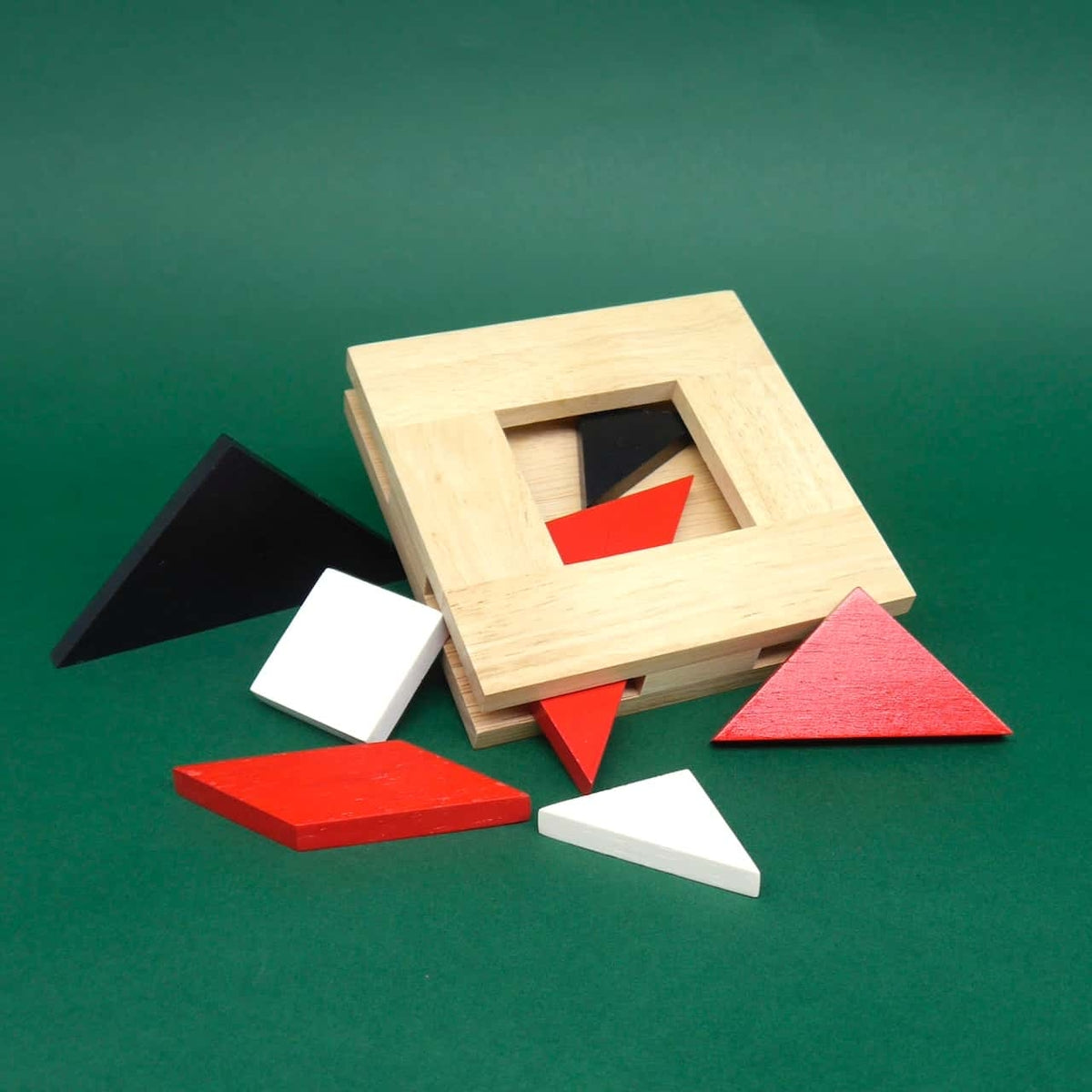 Holzrahmen mit halb eingesetzten roten, schwarzen und weißen Dreiecken – herausforderndes Tangram zum Selbst-Zusammenlegen.
