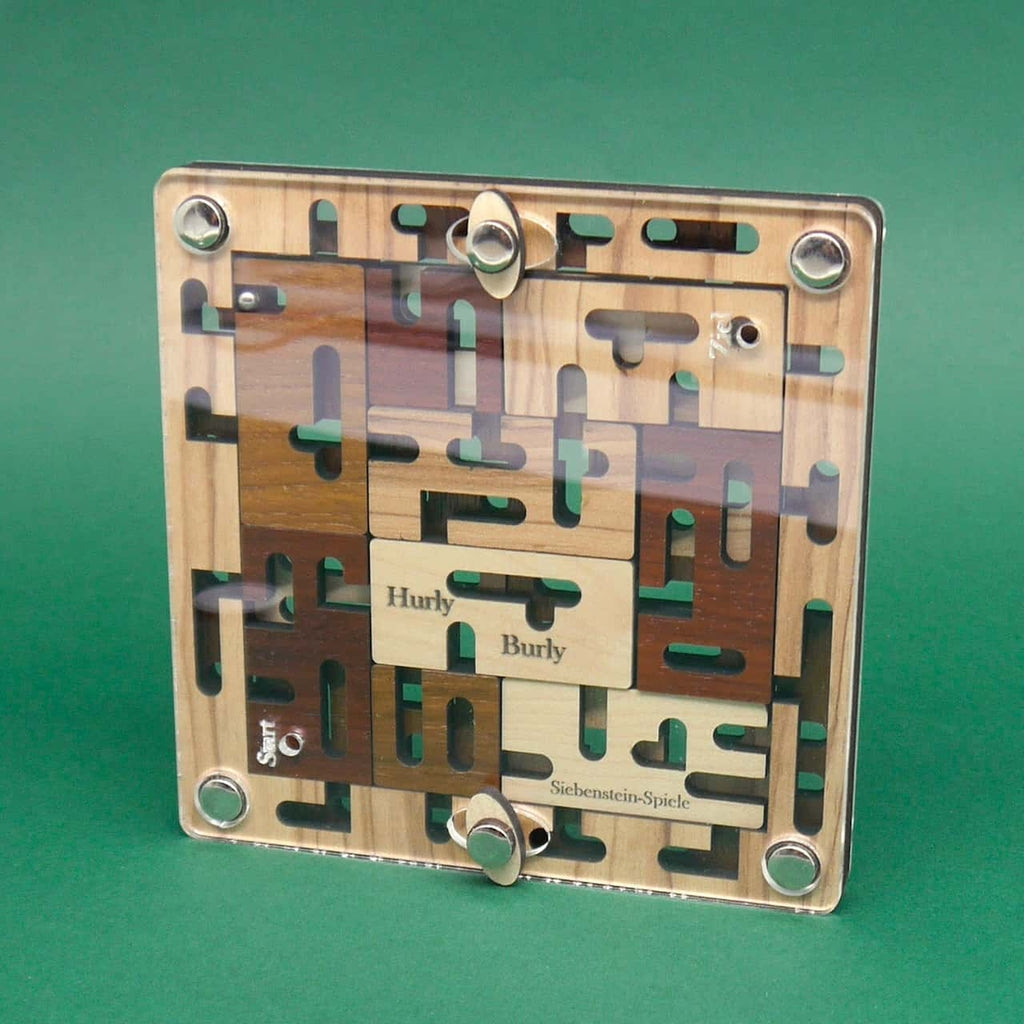 Das zusammengesetzte „Hurly Burly“-Labyrinth steht aufrecht, die Acrylscheibe schützt die verschachtelten Holzbahnen; Start- und Zielöffnungen sowie eine Stahlkugel sind sichtbar.