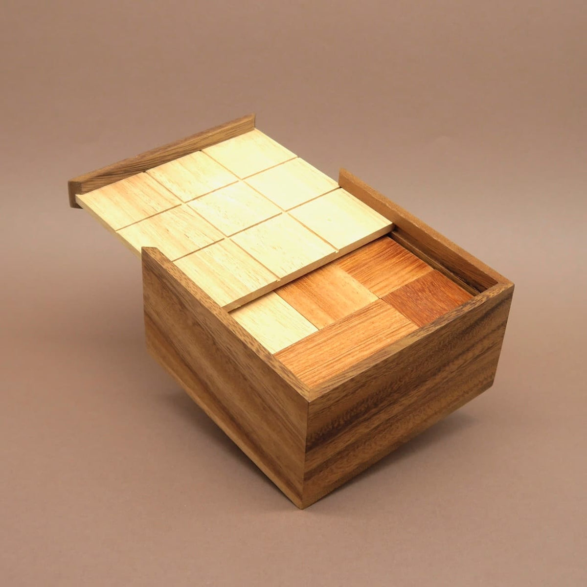 Familienspiel aus Holz: I Qube Box mit Schiebedeckel und quadratischen Puzzleteilen, regt zum Denken an.