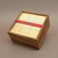 Holzspiel I Qube: quadratische Box mit Schiebedeckel und ROMBOL-Band – kompaktes Taktikspiel.