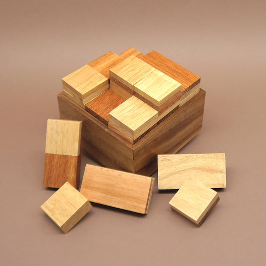 Strategiespiel I Qube: Stapelspiel aus Holz mit rechteckigen Bausteinen, teils auf der Box angeordnet.