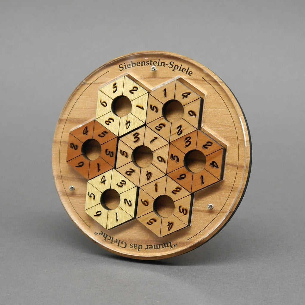 Das komplett ausgefüllte Zahlenpuzzle zeigt eine wabenförmige Fläche aus hellen und dunklen Sechseckringen mit Ziffern und zentralen Löchern.