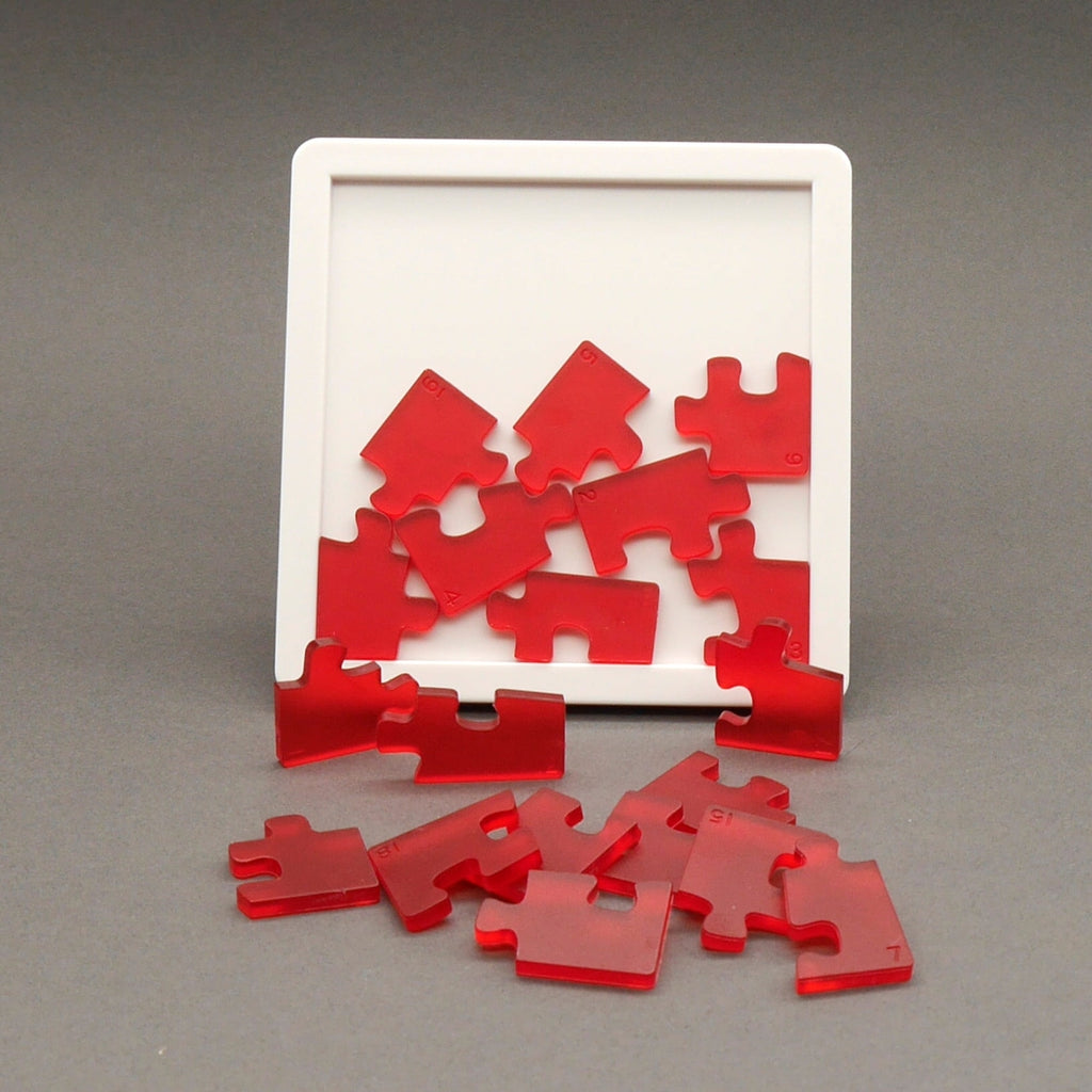 Geduldsspiel mit roten transparenten Puzzleteilen in weißem Rahmen auf neutralem Hintergrund.