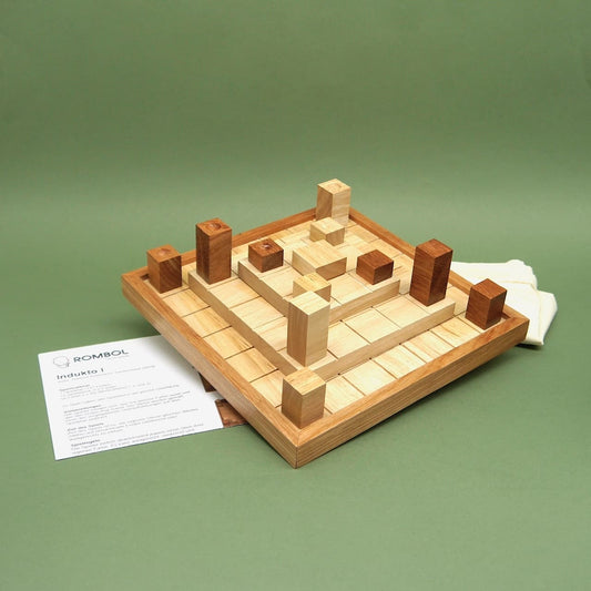 Indukto Brettspiel komplett aufgebaut mit Holzklötzen, Spielbrett und Anleitung; Baumwollbeutel daneben.