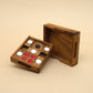 Geöffnetes Holzpuzzle mit roten, weißen und schwarzen Spielsteinen – ein raffiniertes Logikspiel für Geduldige.