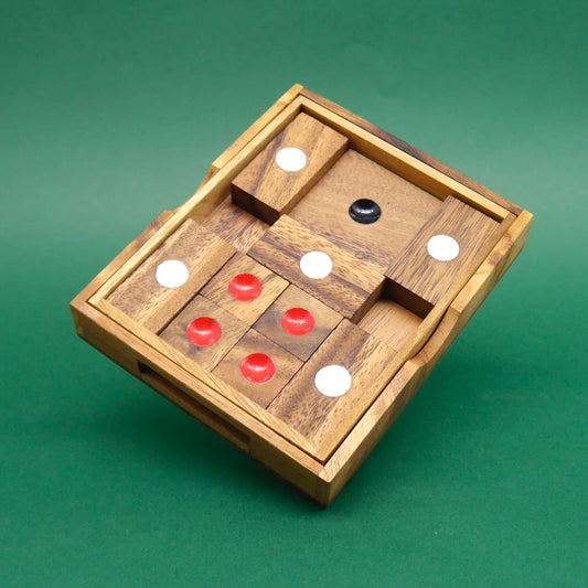 Quadratisches Holzpuzzle aus Holzklötzchen mit weißen und roten Punktmarkierungen, sauber eingesetzt vor grünem Hintergrund.