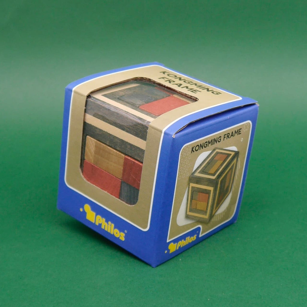 Verpackte Knobelbox mit durchsichtigem Sichtfenster, darin ein fertiges Kongming-Puzzle aus buntem Holz.