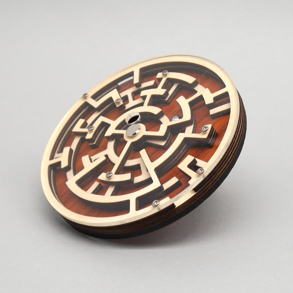 Seitlich aufgenommene Perspektive eines runden Holzpuzzles mit Labyrinthstruktur und glänzenden Metallschrauben.