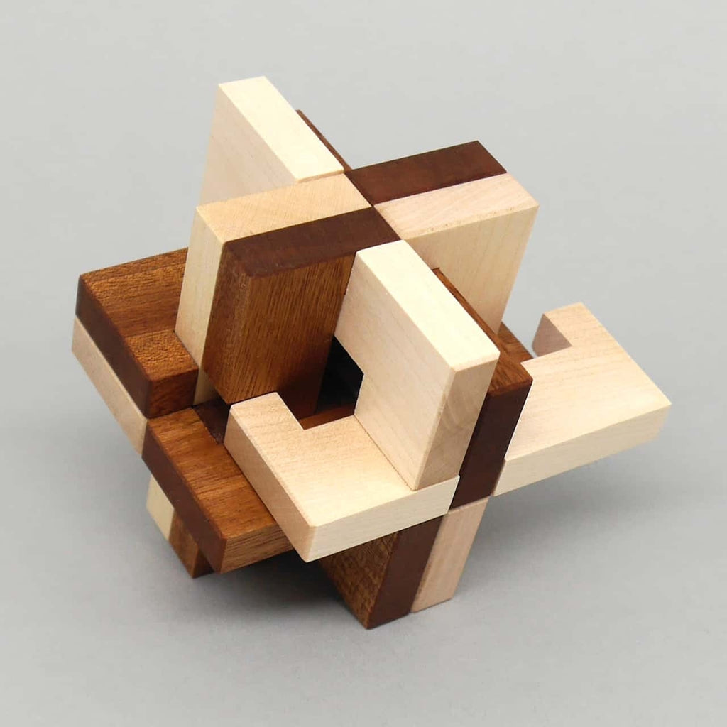 Holzpuzzle im teilzerlegten Zustand; einige helle und dunkle Leisten gleiten heraus und zeigen die innere Verzahnung des Steckpuzzles.