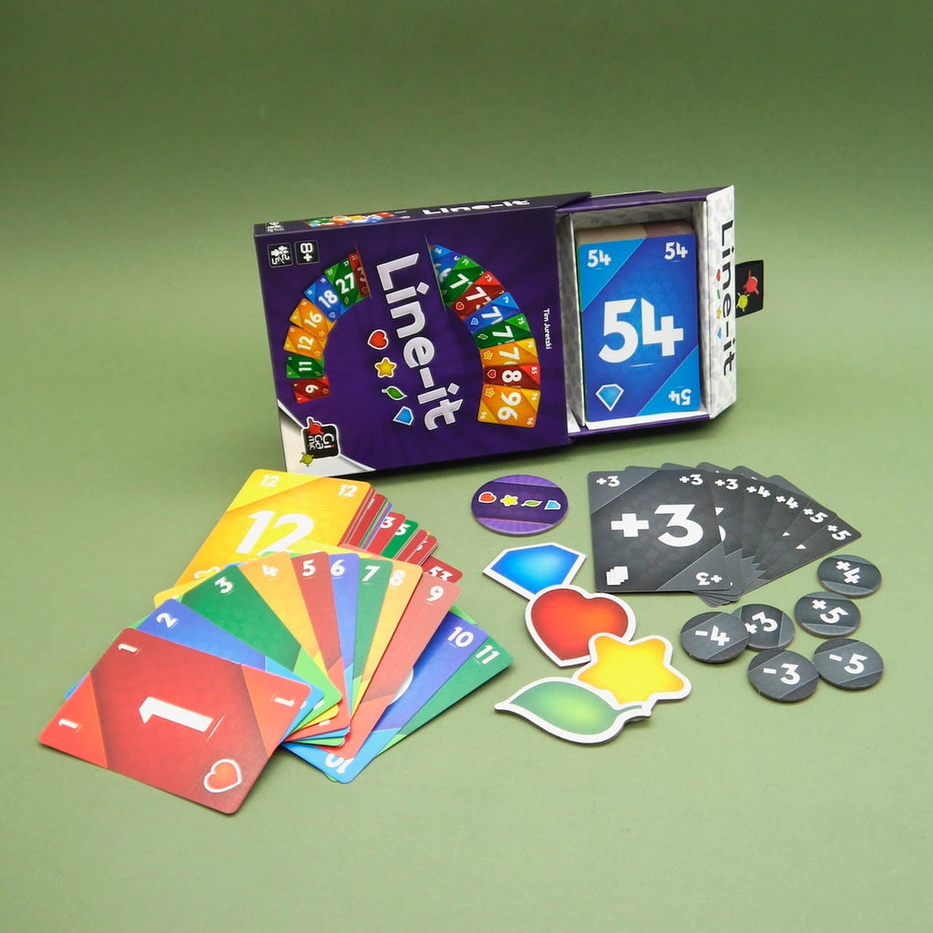 Line-it Gesellschaftsspiel: geöffnete Box mit bunten Zahlenkarten, Markern und Spielmaterial auf grünem Hintergrund.
