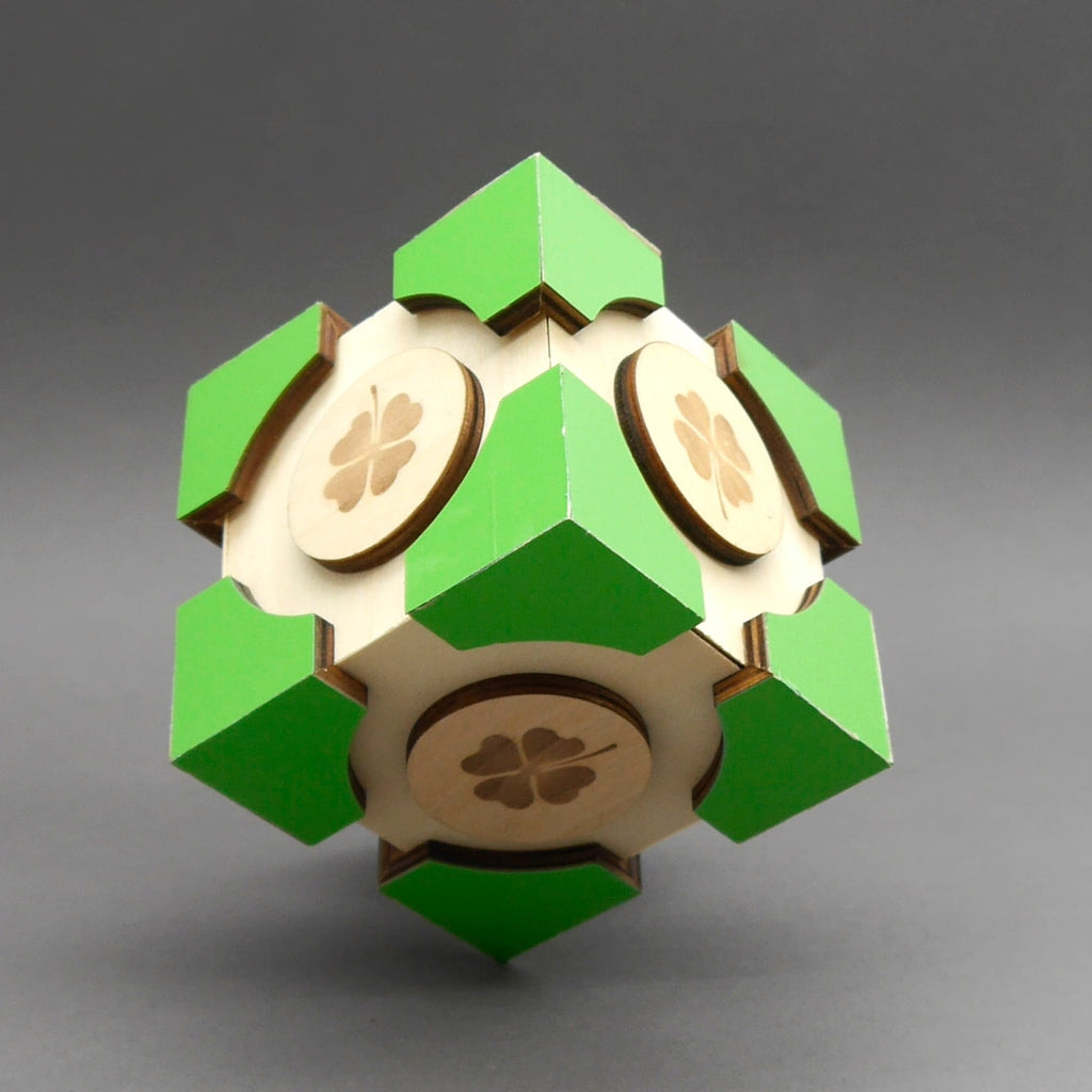 Lucky Secret Holzbox in ungewöhnlicher Diamantform mit grünen Spitzen und mehreren gravierten vierblättrigen Kleeblättern.