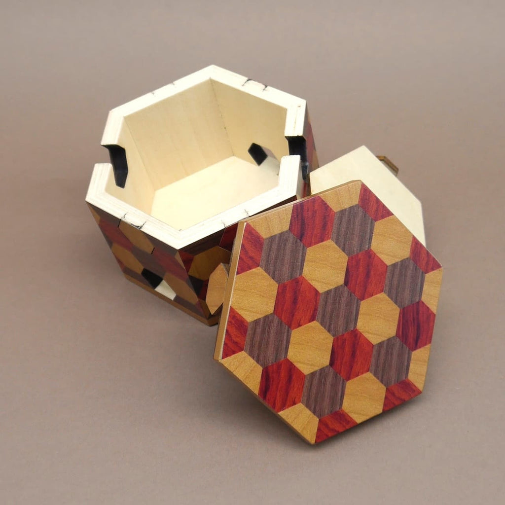 Geöffnete Knobelbox mit wabenförmigem Intarsienmuster, wie eine kleine Schatztruhe.