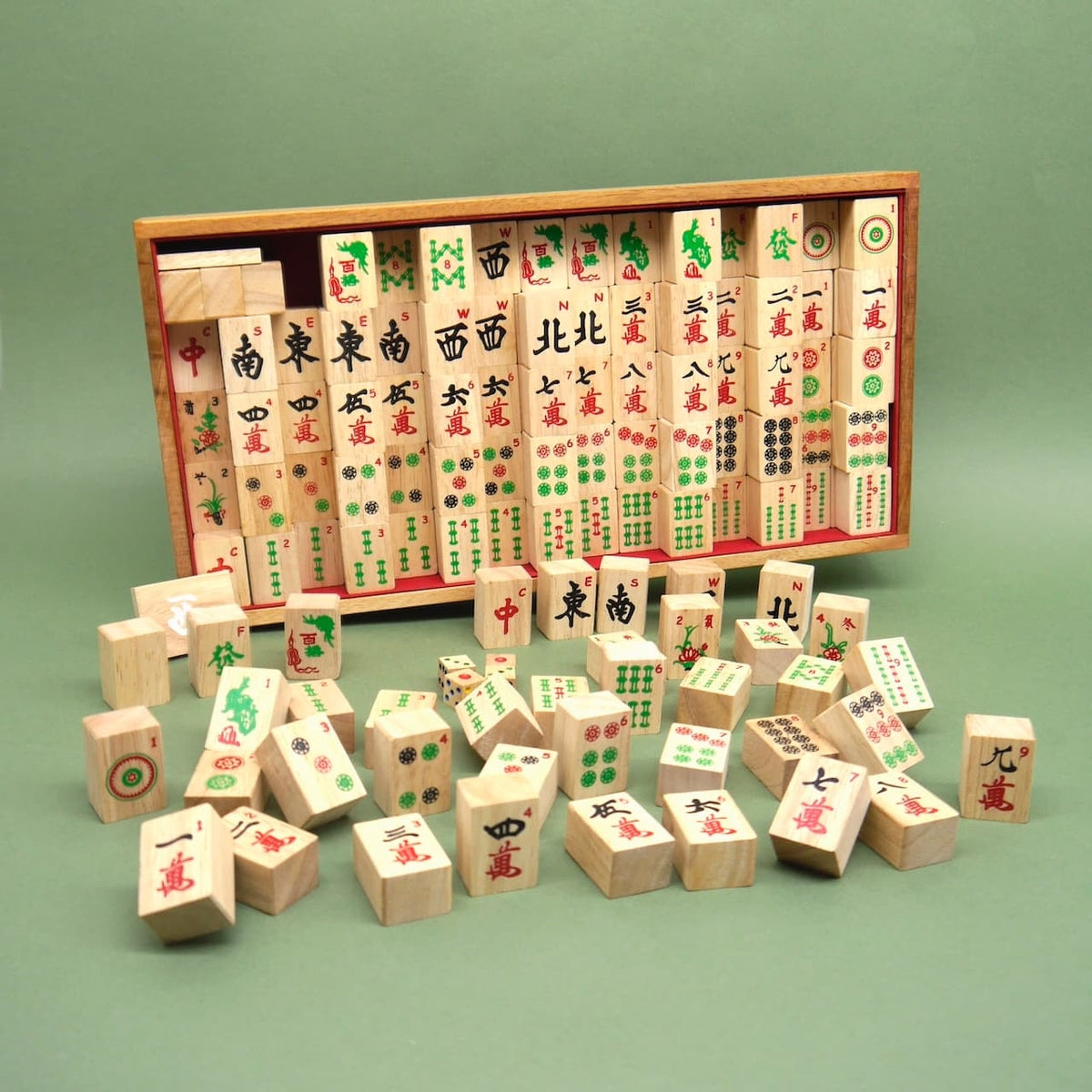 Offene Mahjong-Spielbox mit verstreut liegenden Holzsteinen – ein klassisches Strategiespiel aus Holz.